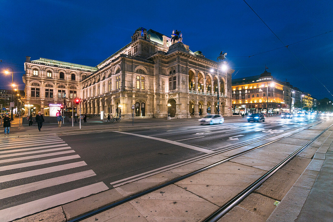 Beleuchtete Wiener Staatsoper über Straße nachts, Wien, Österreich