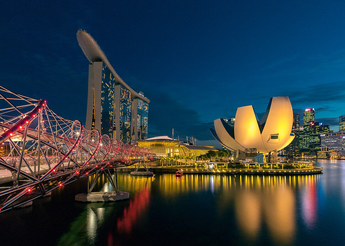 Helix Bridge and illuminated building of ArtScience Museum at night, Singapore