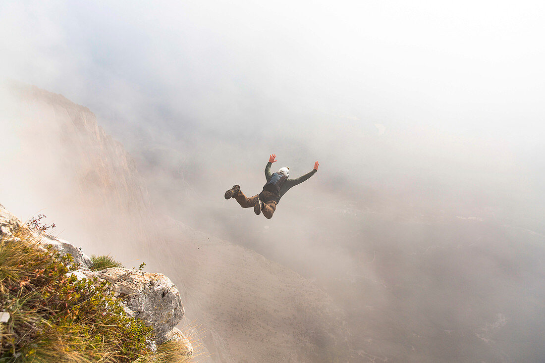 Base jumper mid air right after cliff jump during foggy weather, Brento, Venetien, Italy