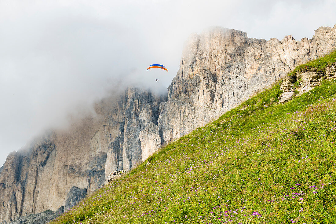 Ein Gleitschirmflieger vor der Südwestseite der Rotwand, Rosengartengruppe, Dolomiten, Trentino, Südtirol, Alto Adige, Italien