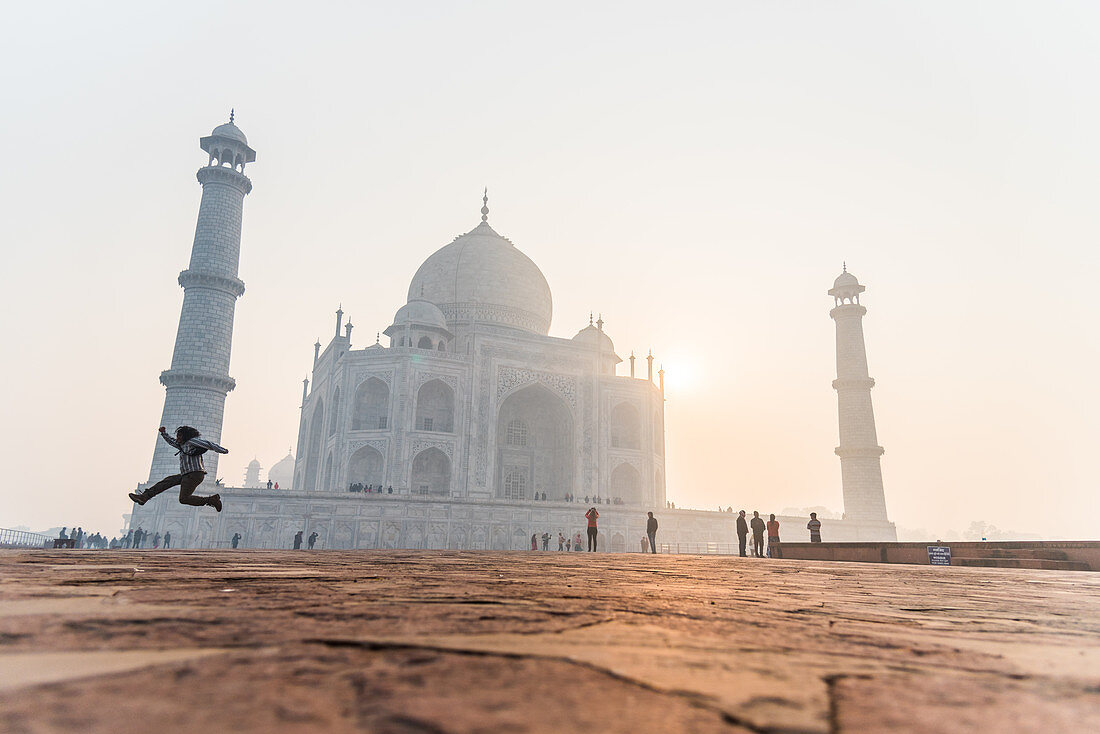 Sonnenaufgang hinter dem Taj Mahal, springender Mann im Vordergrund, UNESCO-Weltkulturerbe, Agra, Uttar Pradesh, Indien, Asien