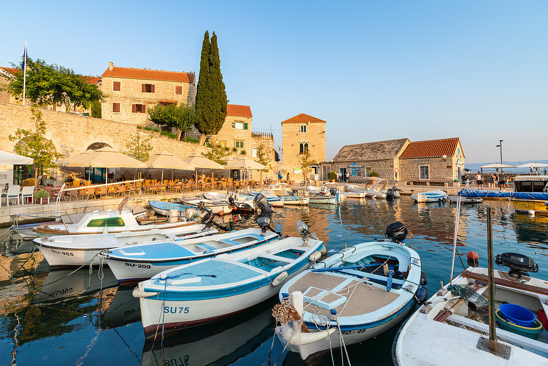 Boats at the pier of the town at sunset, Bol, Brac island, Split-Dalmatia county, Croatia, Europe