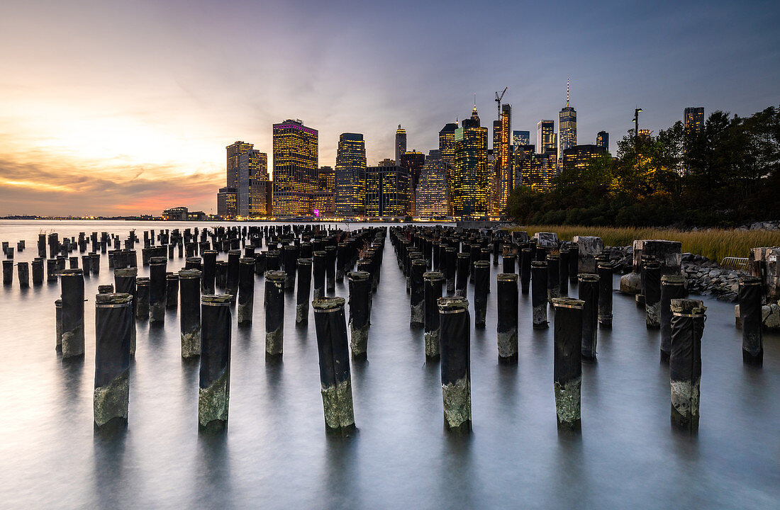 Long exposure of the lights of Lower Manhattan during sunset as seen from Brooklyn Bridge Park, New York, United States of America, North America