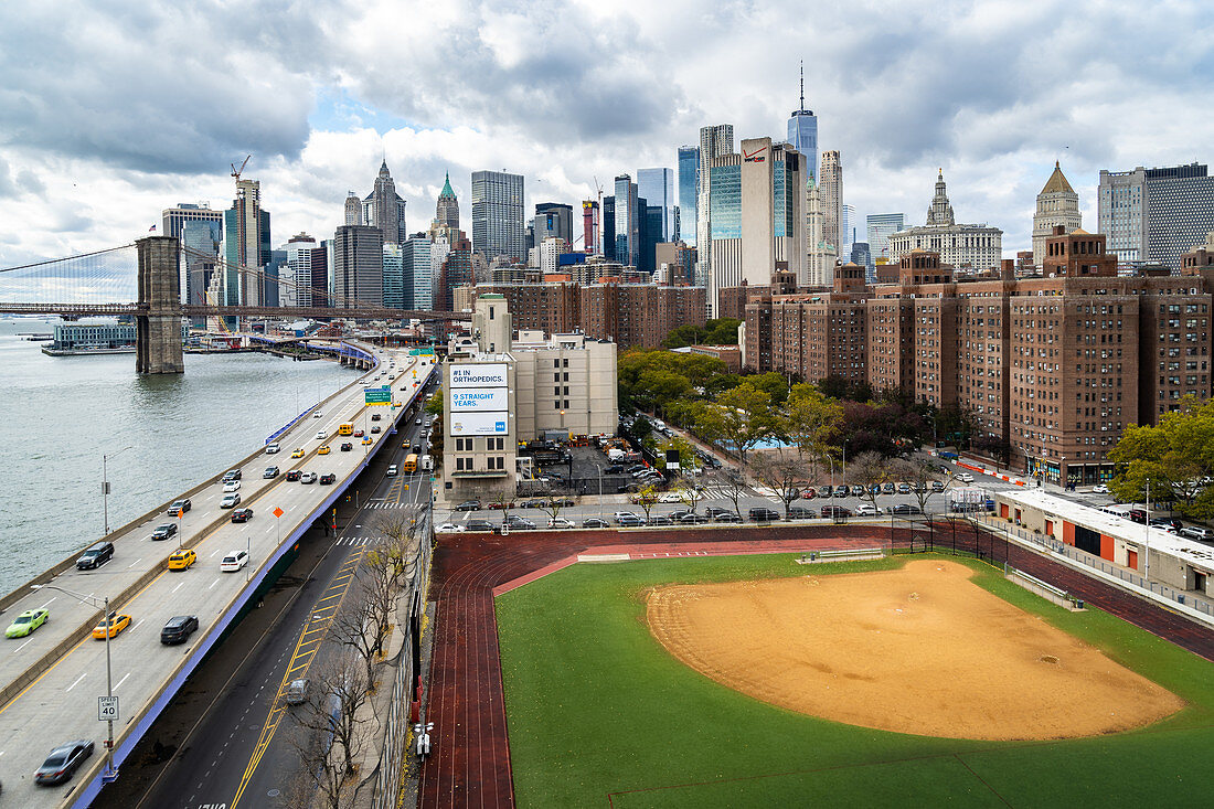 A baseball field along the FDR and East River with views towards the Brooklyn Bridge and Lower Manhattan, New York, United States of America, North America