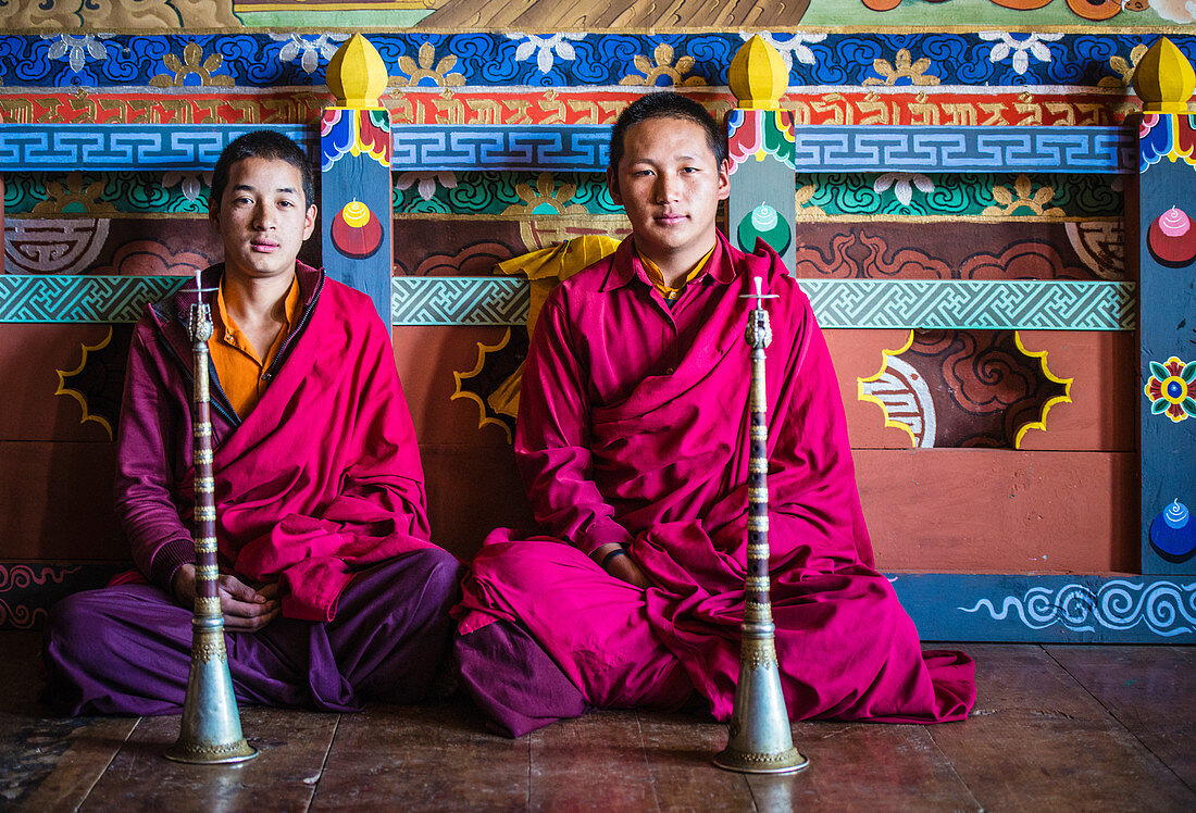 Asiatische Mönche sitzen auf dem Tempelboden, Bhutan, Königreich Bhutan
