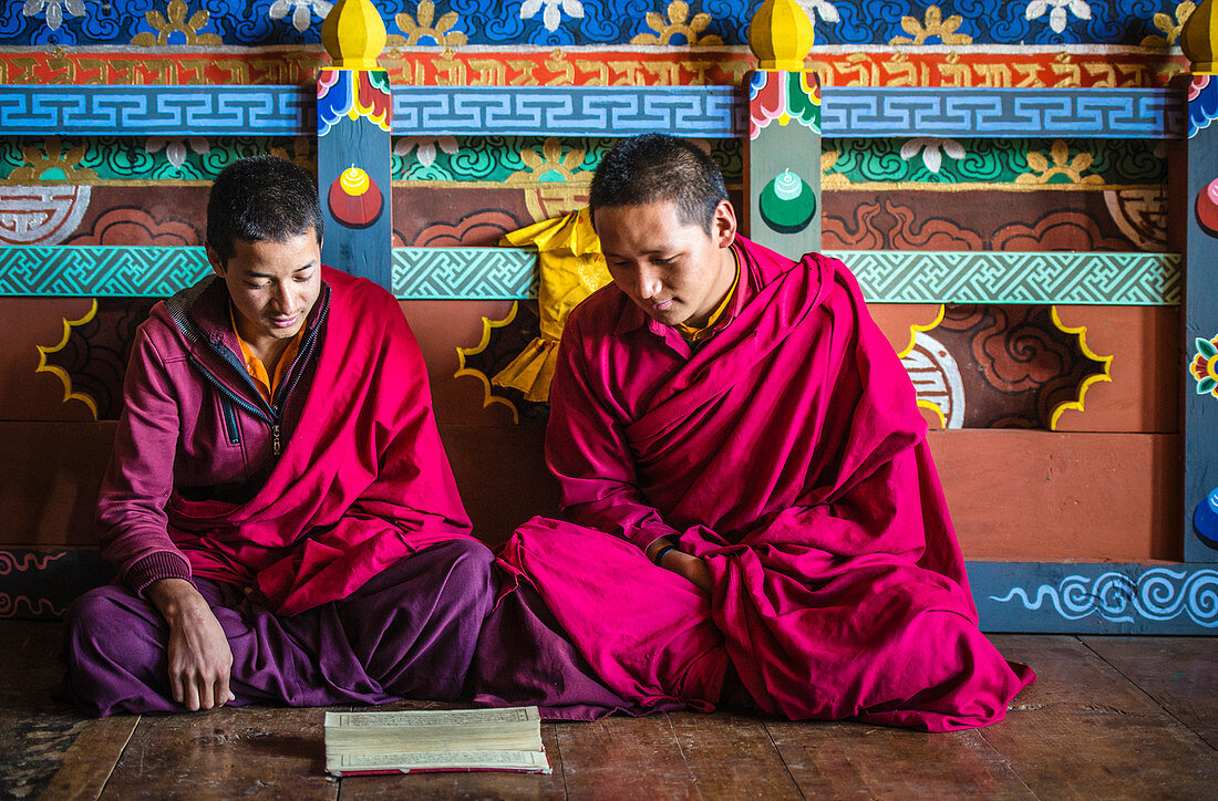Asiatische Mönche lesen auf dem Tempelboden, Bhutan, Königreich Bhutan