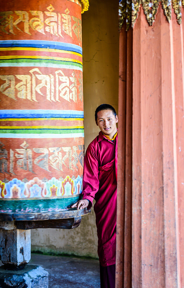 Asian monks standing by pillar in temple, Bhutan, Kingdom of Bhutan