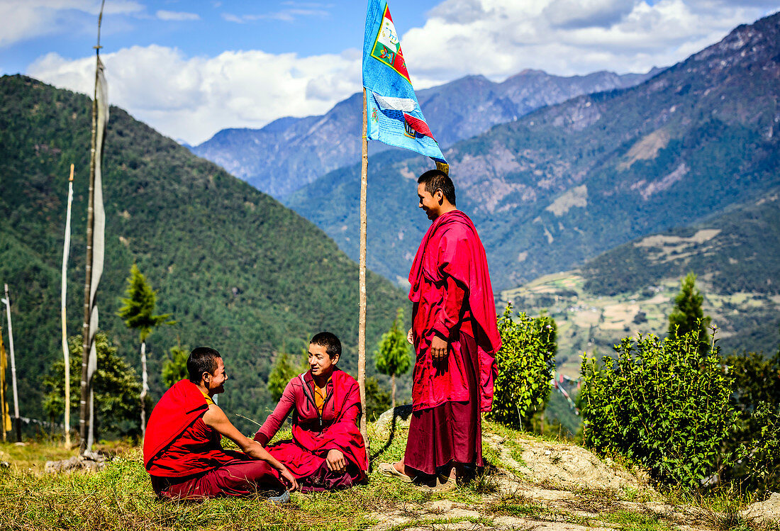 Asian monks with flag on remote hilltop, Bhutan, Kingdom of Bhutan