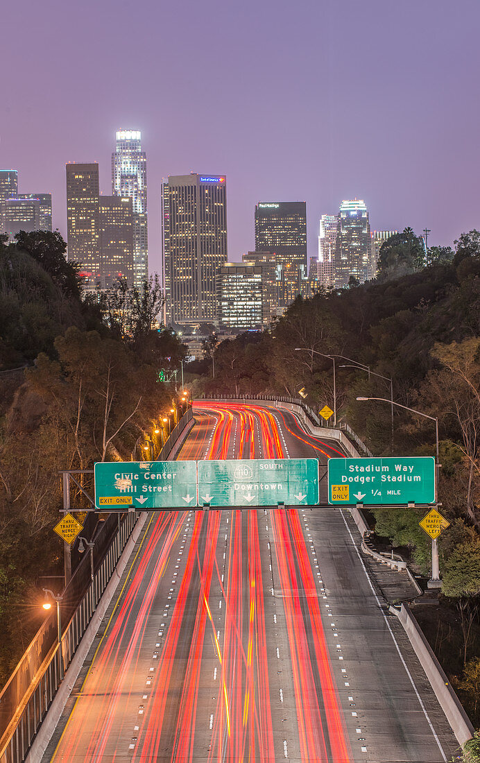 Los Angeles Skyeline über der belebten Autobahn, nachts beleuchtet, Kalifornien, Vereinigte Staaten