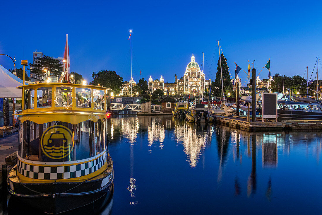 Parliament Buildings and harbor illuminated at dusk, Victoria, British Columbia, Canada