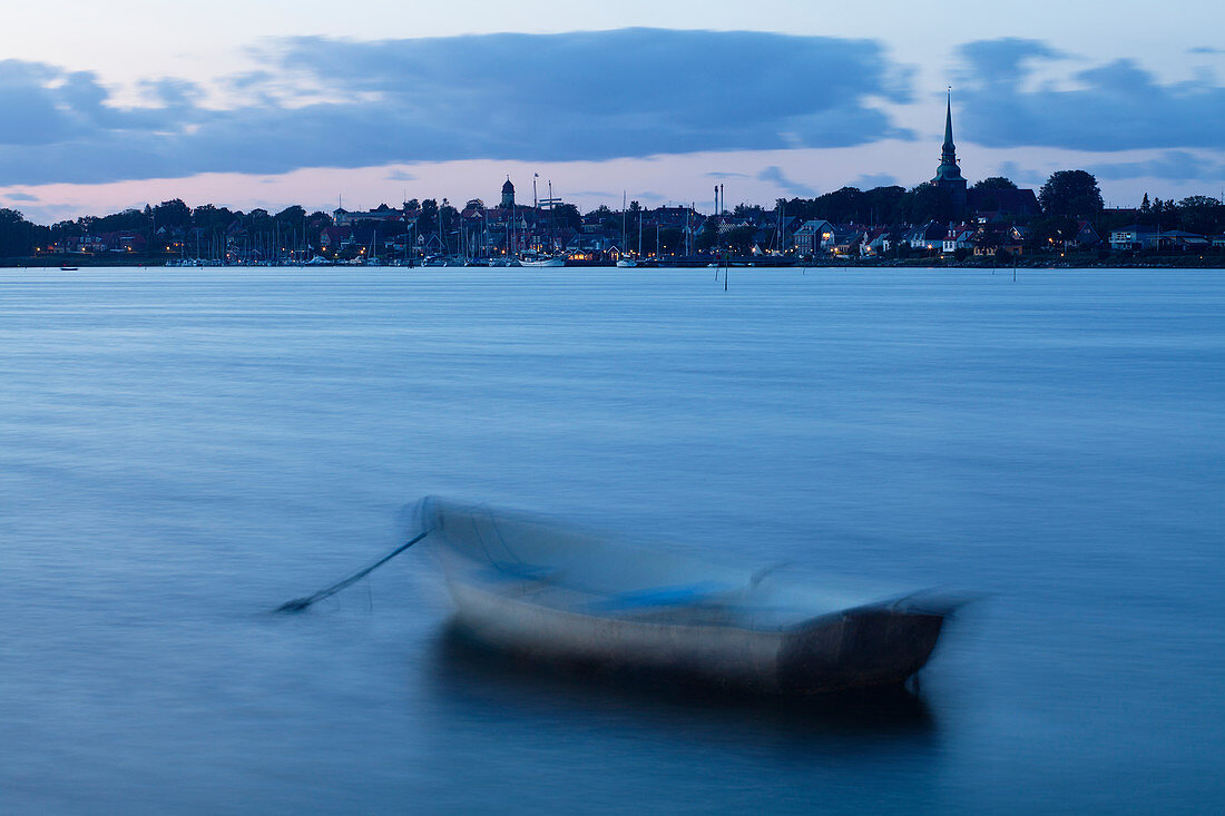 Boot vor der Küste in ruhigem Gewässer, Skyline in der Ferne, Dänemark,