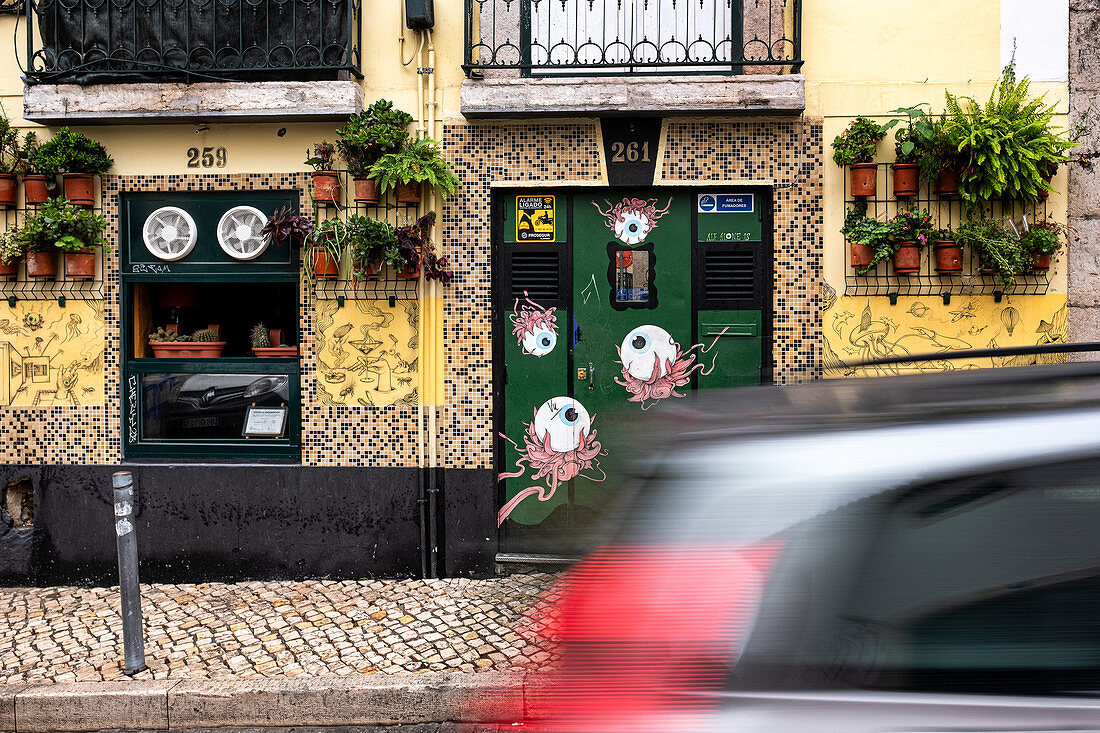 Fassade einer Kneipe mit vorbeifahrendem Auto in Lissabon, Portugal