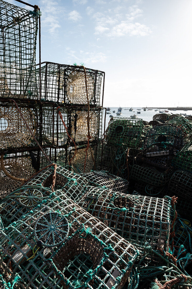 Gestapelte Fangkörbe im Fischerhafen von Cascais, im Hintergrund Fischerboote, Cascais, Portugal
