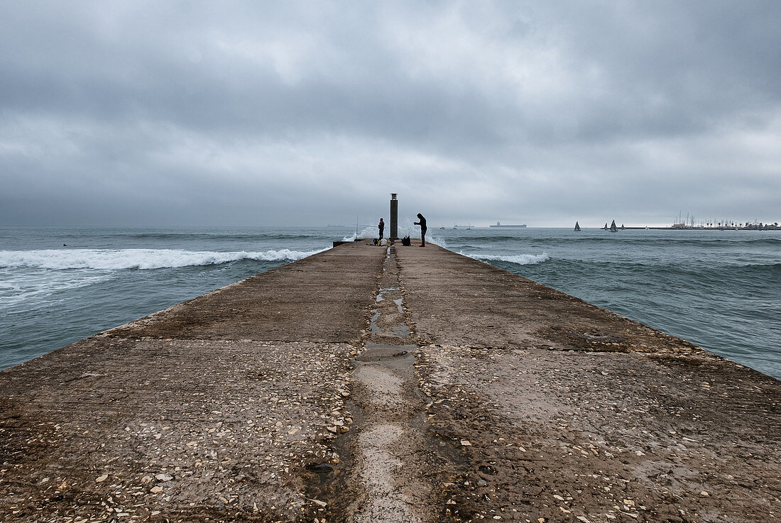 Fisherman on concrete footbridge, Praia das Moitas, Cascais, Portugal