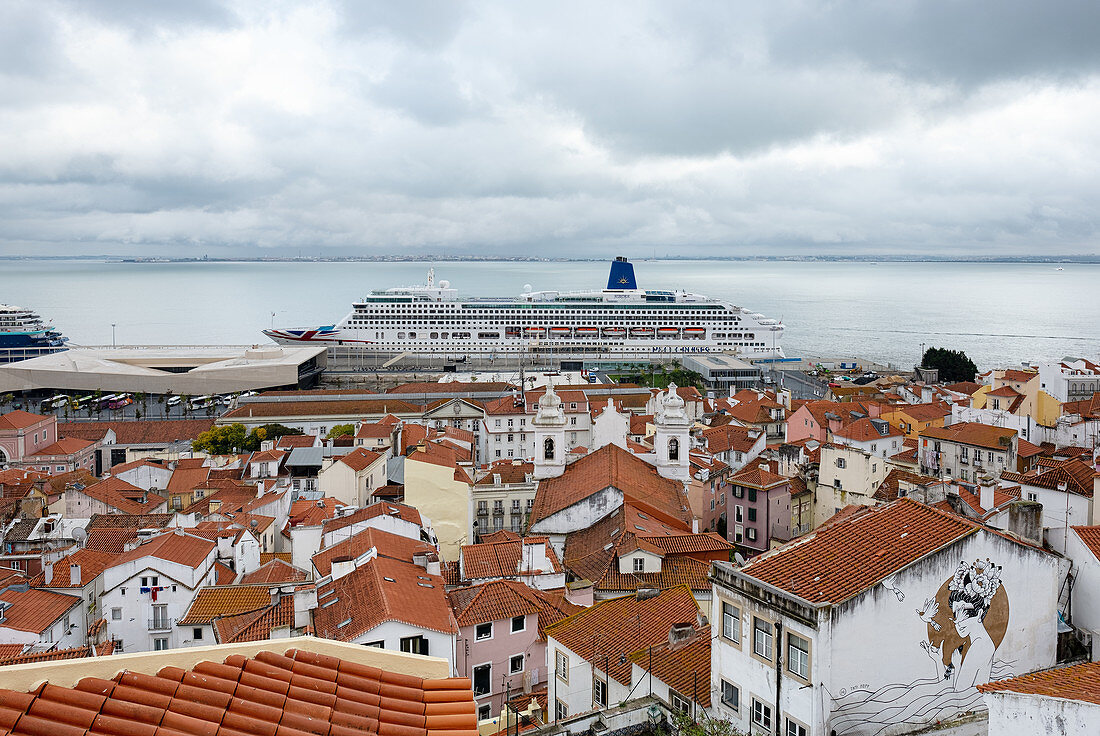 Blick über die Dächer auf ein Kreuzfahrtschiff im Hafen von Lissabon, Portugal