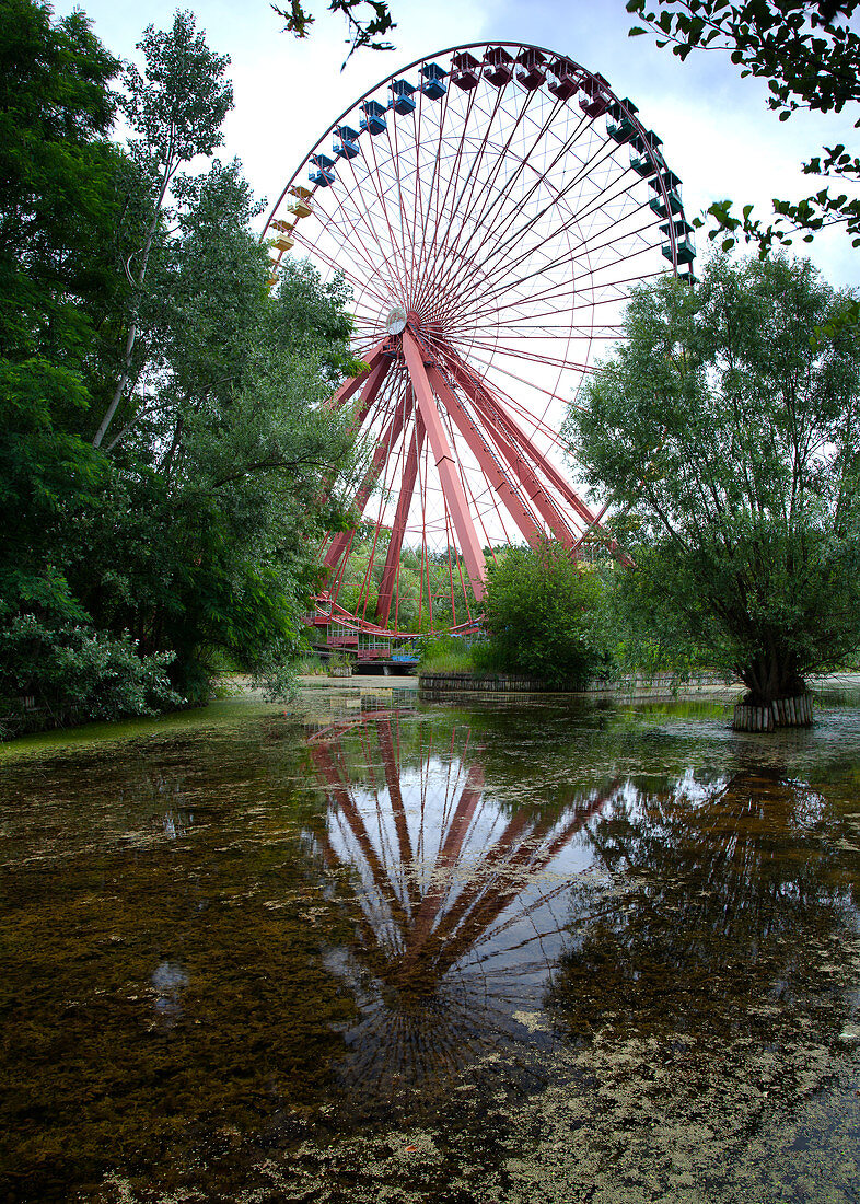 Overgrown ferris wheel in the disused amusement park in the Plänterwald, Treptow, Berlin, Germany