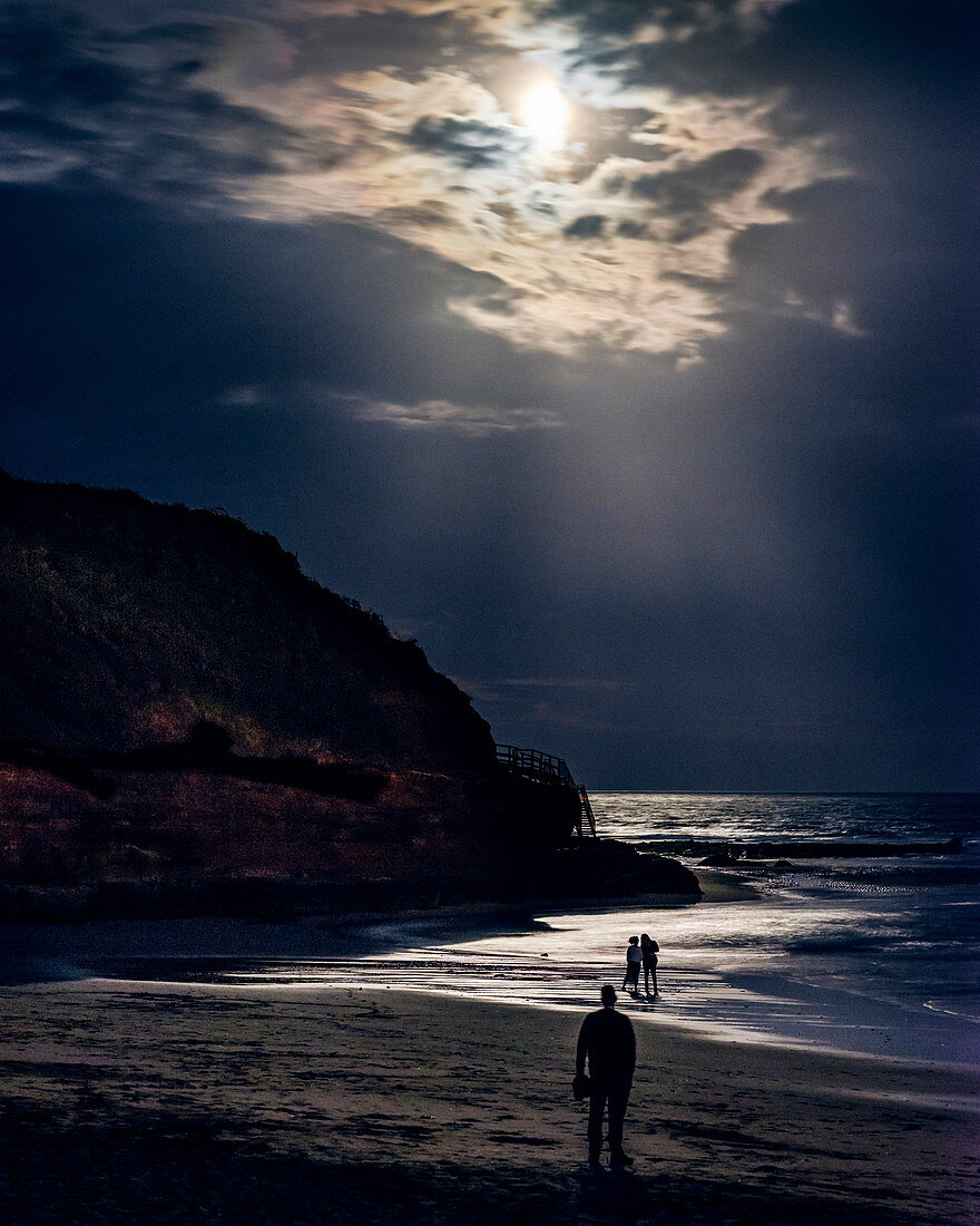 Zwei beim Paddeln beim Vollmond kurz nach einer Sonnenfinsternis in Orcombe Point, Exmouth, Devon, England, Großbritannien, Europa