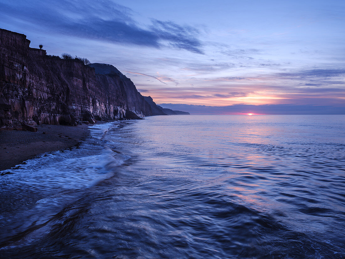 Sun peeps below a cloud bank at Sidmouth, Devon, England, United Kingdom, Europe