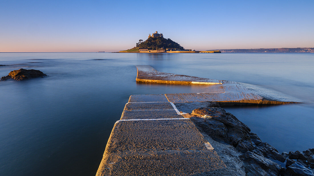 Sunrise on the boat jetty with warm light at St. Michael's Mount in Marazion, Cornwall, England, United Kingdom, Europe