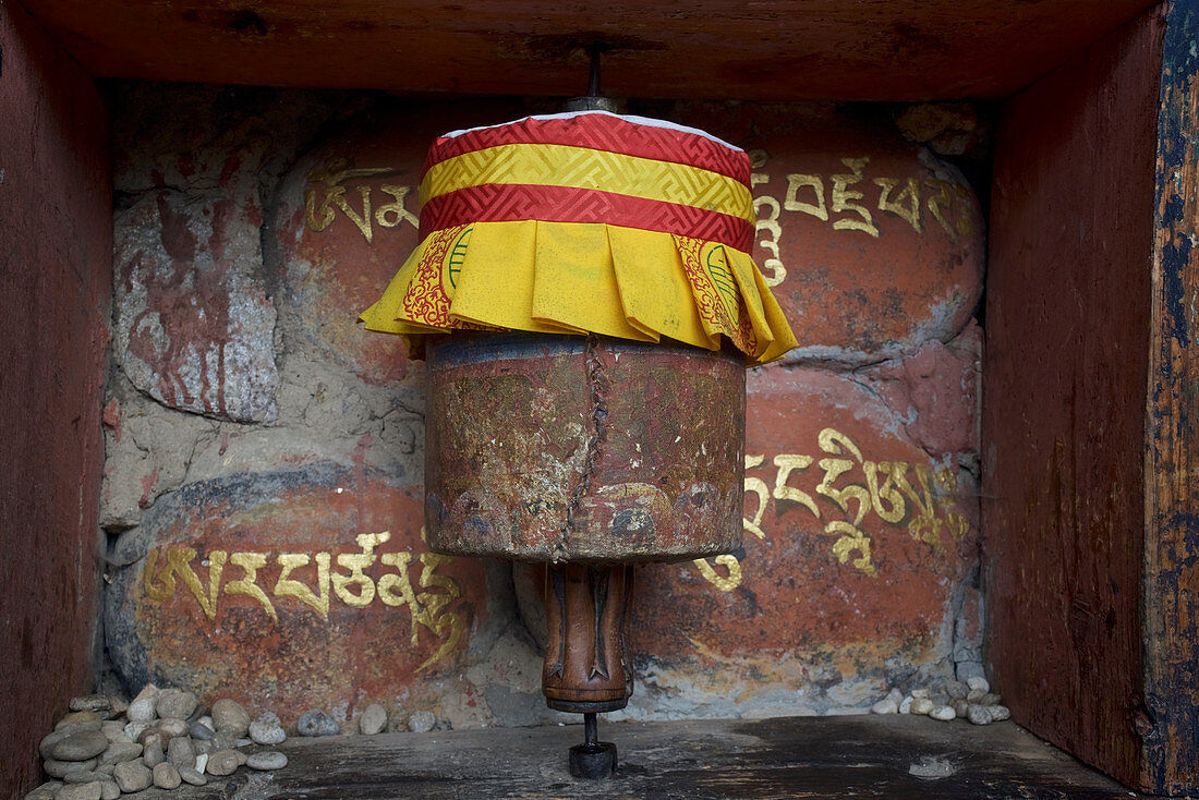 Gebetsmühle mit dem Mantra Om Mani Padme Hum in tibetischer Schrift im Bumthang Tal, Bhutan, Himalaya
