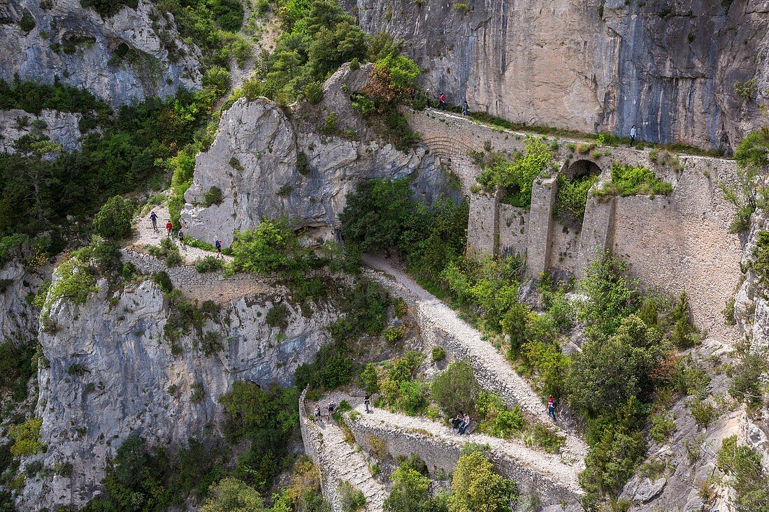 France, Herault, Saint Guilhem Le Desert, Max Negre's cliffs into the Cirque de l'Infernet, walkers on the Via Tolosana on the Route of Compostela, the passage of Fenestrelles fitted out formerly by the monks of the abbey to cross this rocky bolt