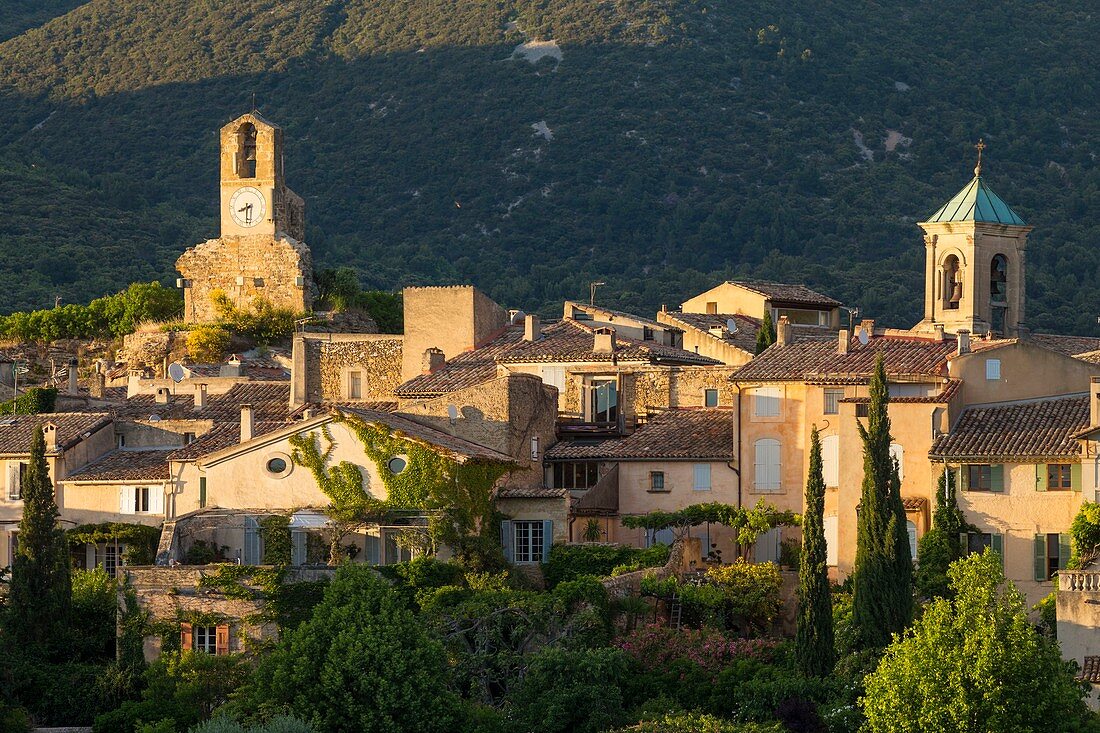 France, Vaucluse, Parc Naturel Regional du Luberon (Natural Regional Park of Luberon), Lourmarin, labelled Les Plus Beaux Villages de France (The Most Beautiful Villages of France), the Tower of the clock and the chocher of the church, the massif of Lubéron in background