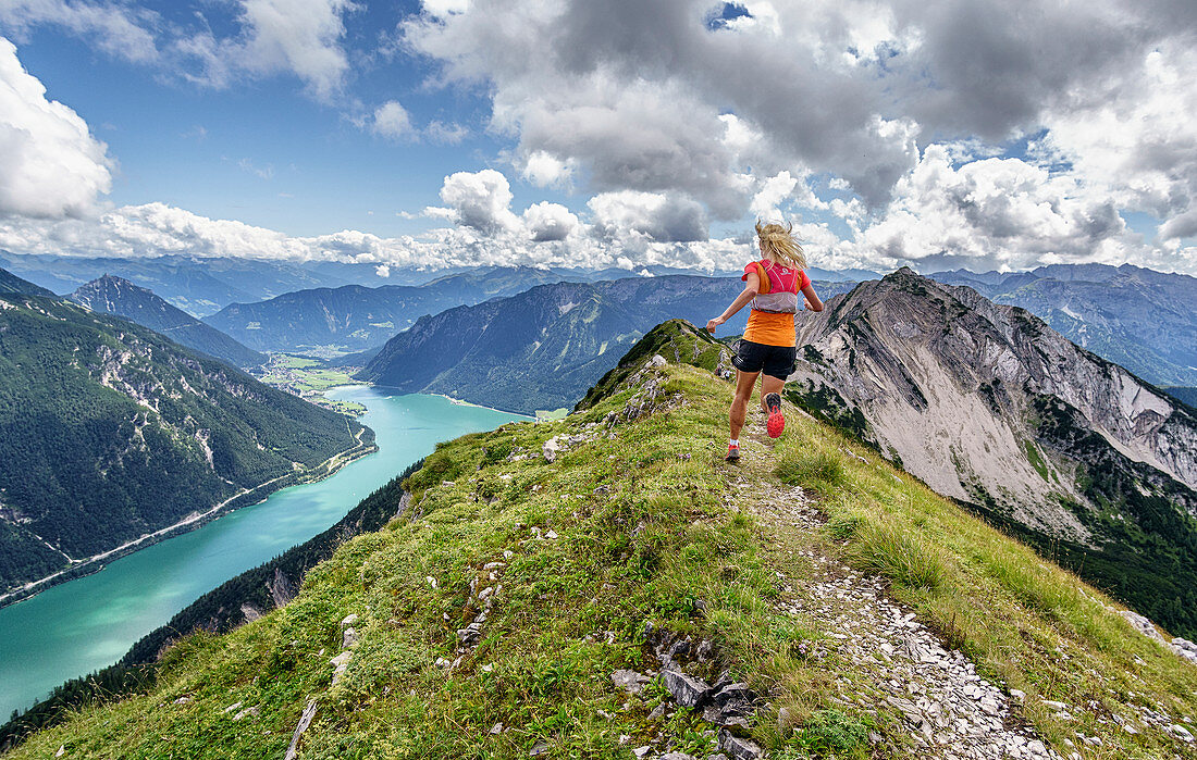 Trailläuferin läuft auf Bergrücken zwischen Seekarspitze und Seebergspitze am Achensee, Tirol, Österreich