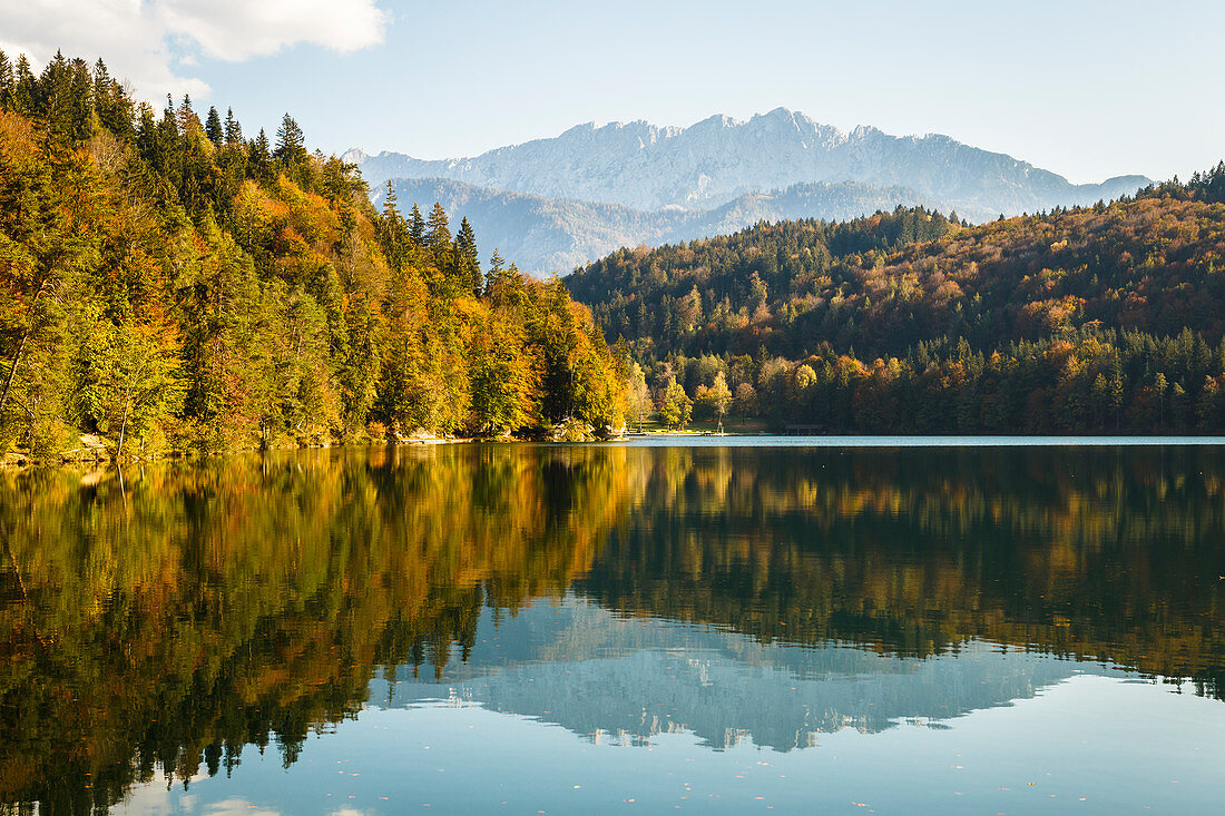 Der Wilde Kaiser spiegelt sich im Hechtsee, umrahmt von herbstlichen Wäldern, Kufstein, Tirol, Österreich