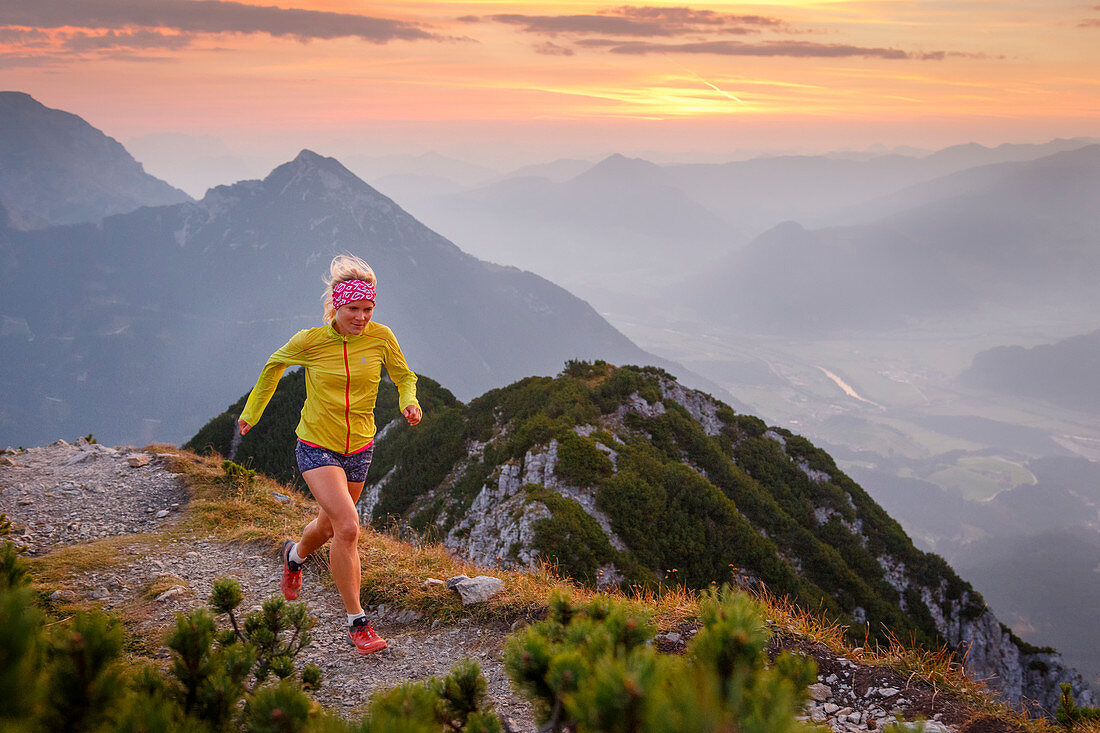 Trailrunner bei Sonnenaufgang am Gipfel des Bärenkopf hoch über dem Inntal, Achensee, Tirol, Österreich