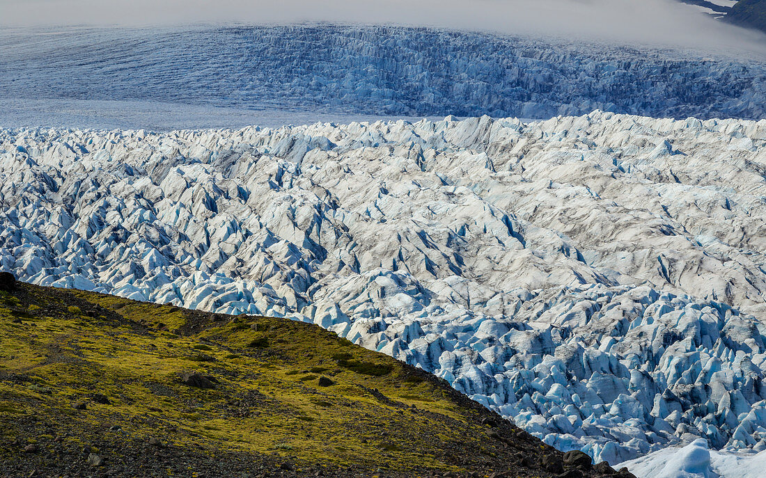 Grüner Hügel vor gigantischem Gletscherbruch, Jökulsárlón, Island