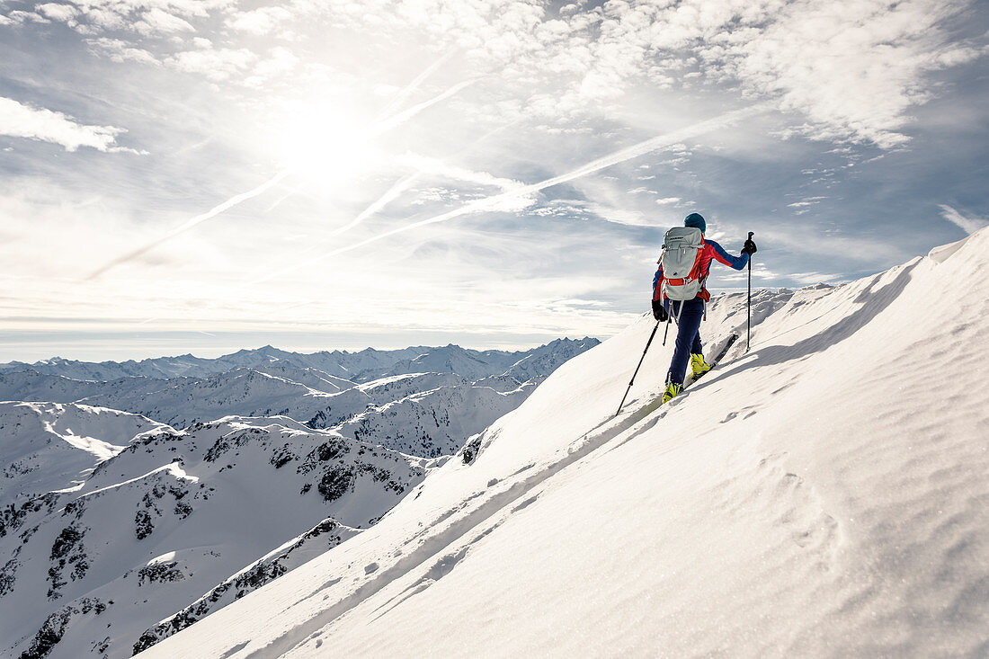 Skitourengeherin steigt durch unberührten Pulverschnee auf, Alpbach Tal, Tirol, Österreich