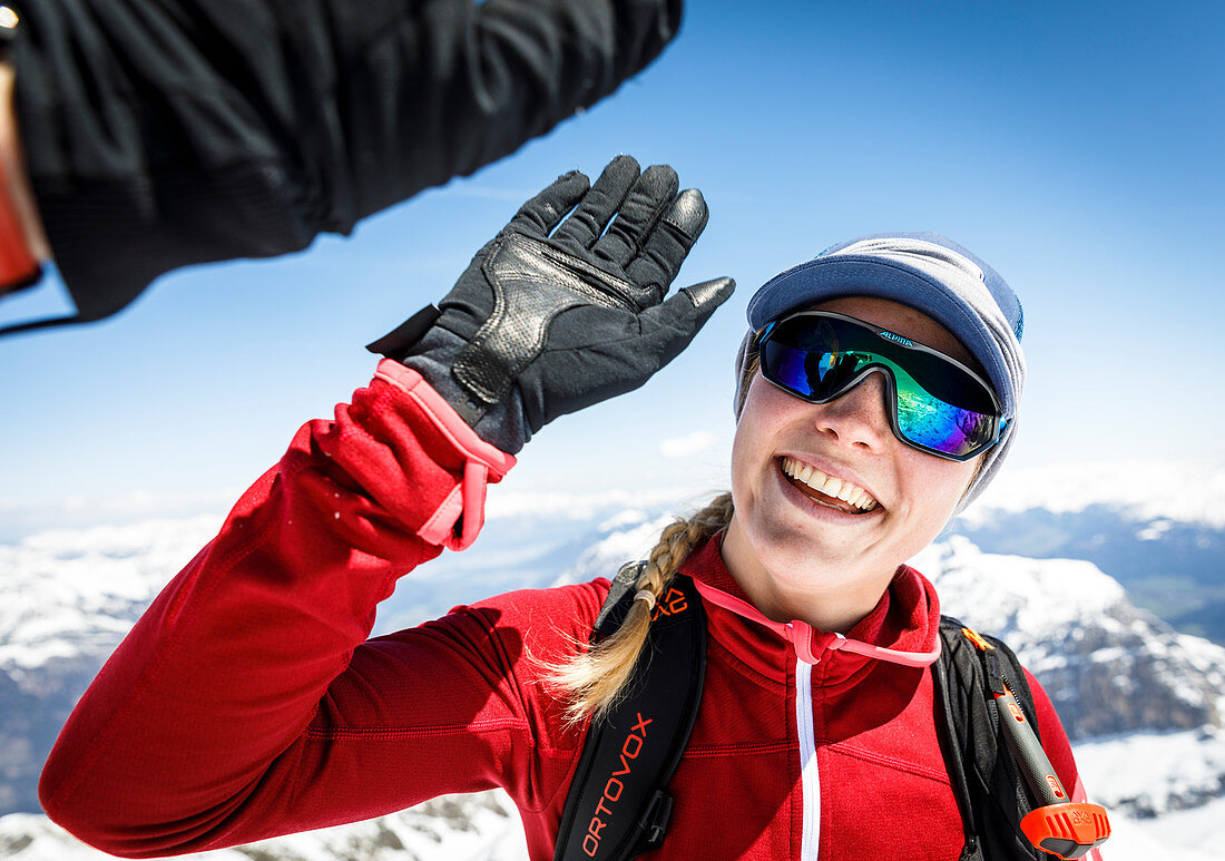 High Five mit einer jungen Ski Alpinistin am Gipfel