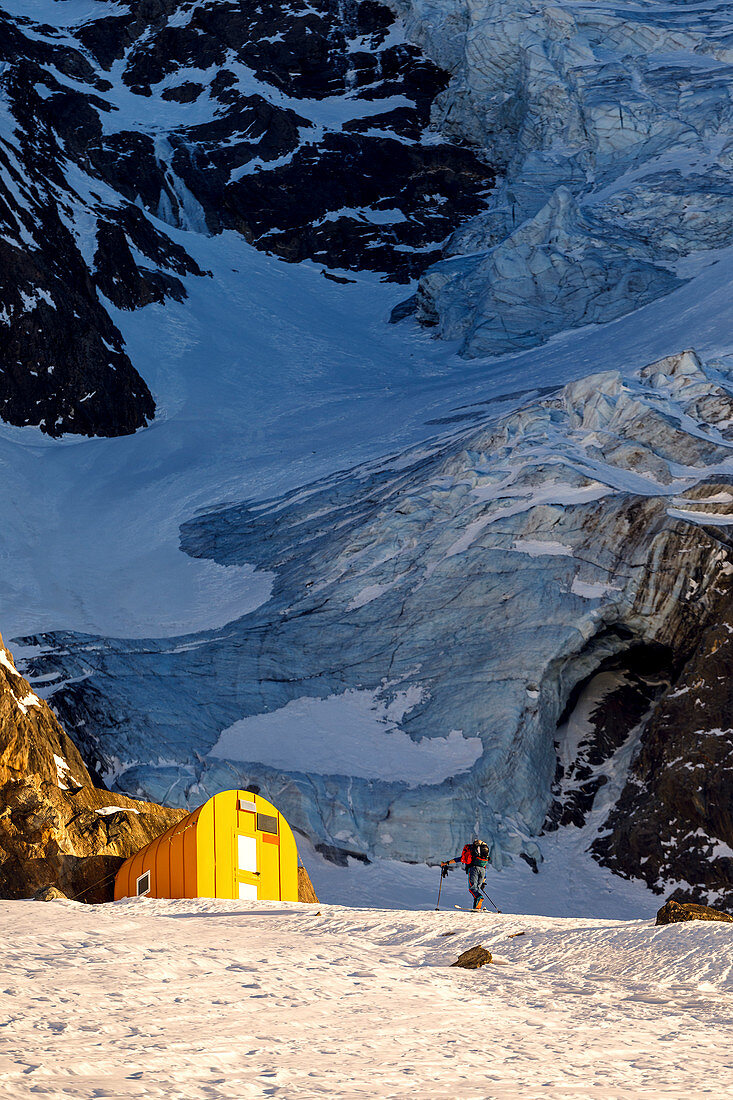 Skialpinistin im Aufstieg zum Günther Messer Biwak mit Gletscherabbruch des Hochferners im Hintergrund, Pfitschertal, Südtirol, Italien