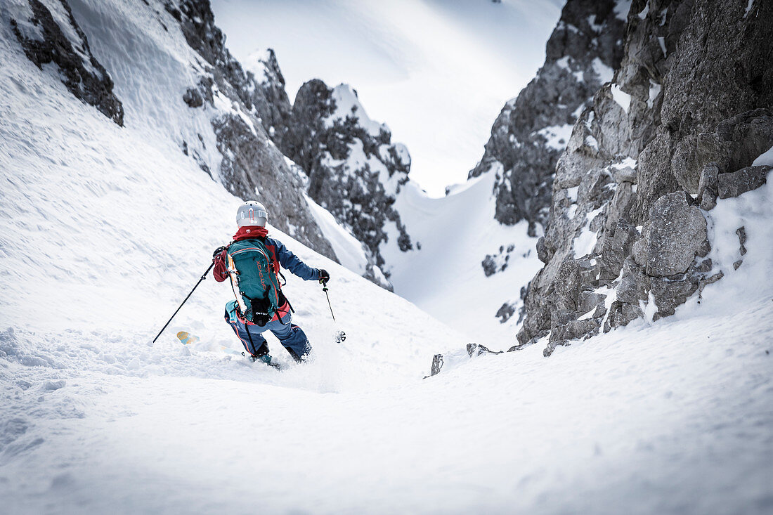 Skialpinistin bei der Abfahrt in einer steilen Rinne, Mieminger Kette, Tirol, Österreich