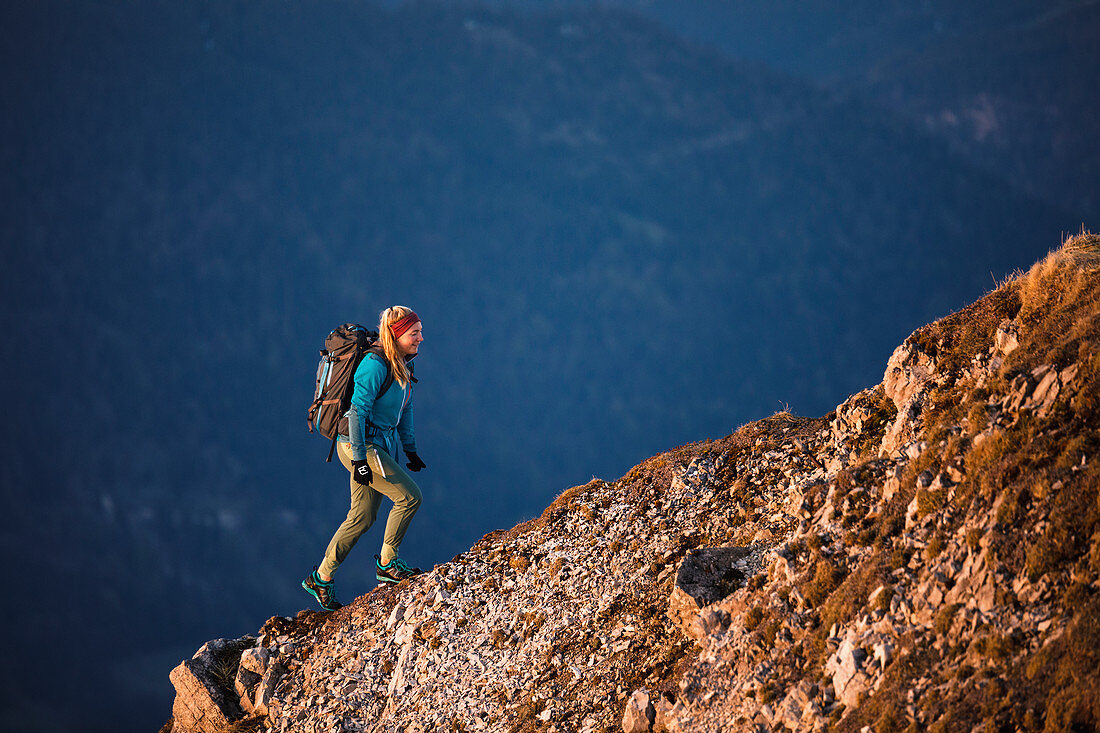 Junge blonde Bergsteigerin steigt über einen gratähnlichen Rücken empor, Karwendel, Tirol, Österreich