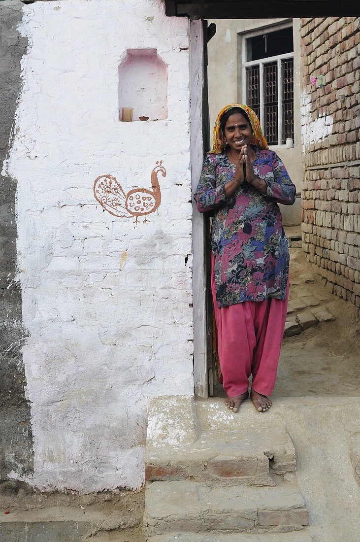 2015, Nandgoan / Nandagram, Vrindavan, Uttar Pradesh, India, villager closes her hands in greeting