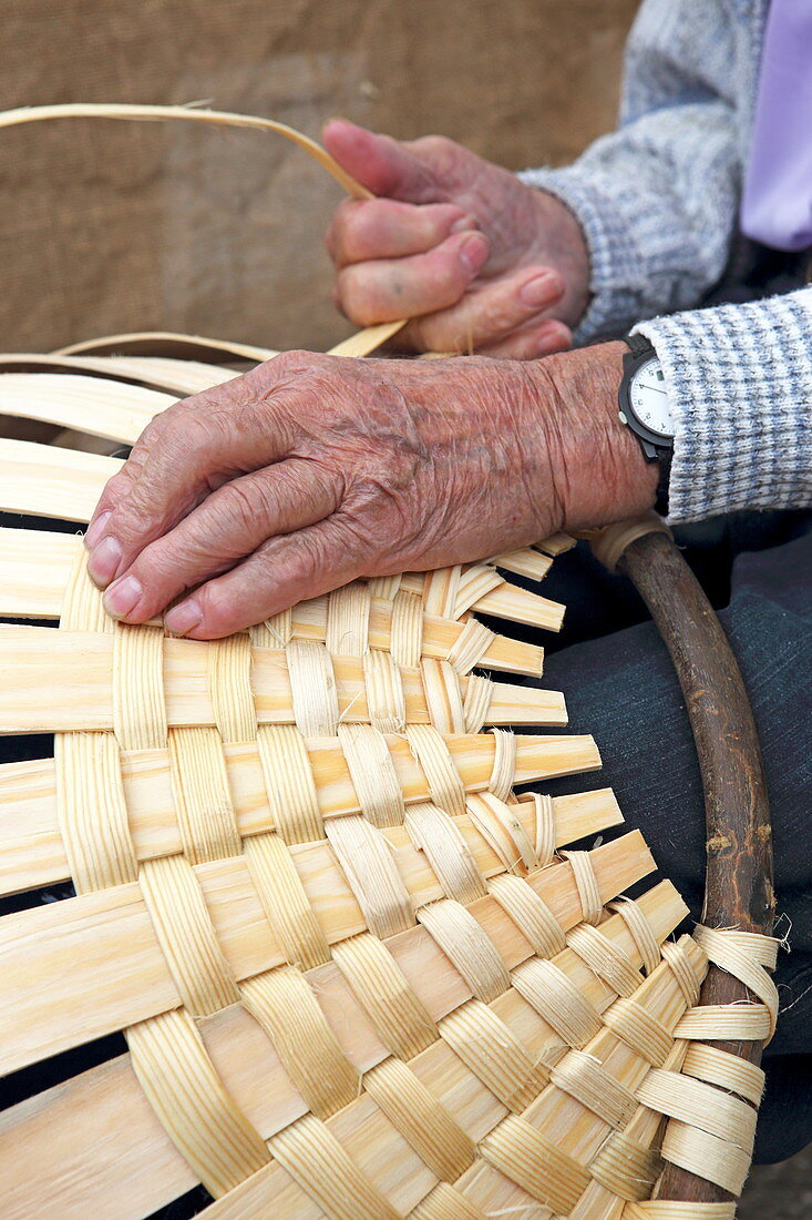 Artisan market in Rothenburg ob der Tauber, man weaving baskets, Bavaria