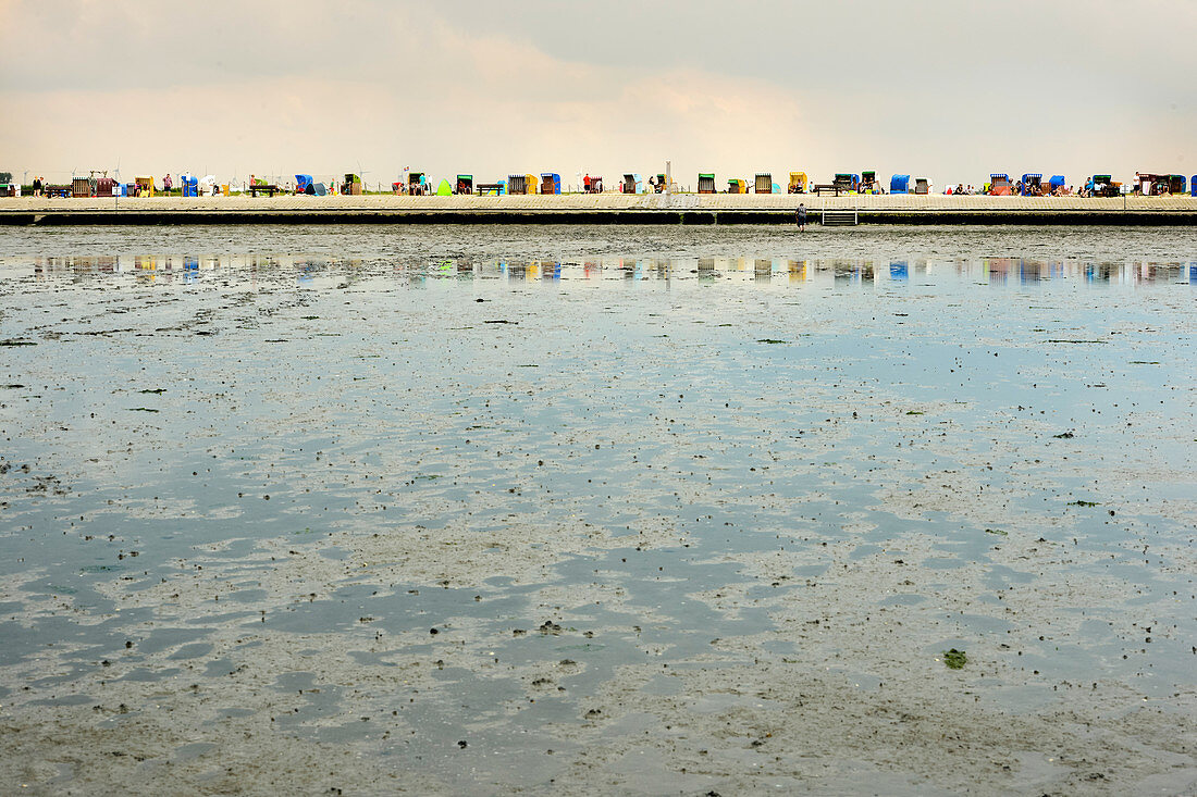 Beach chairs are reflected in the Wadden Sea, north, East Frisia, Germany