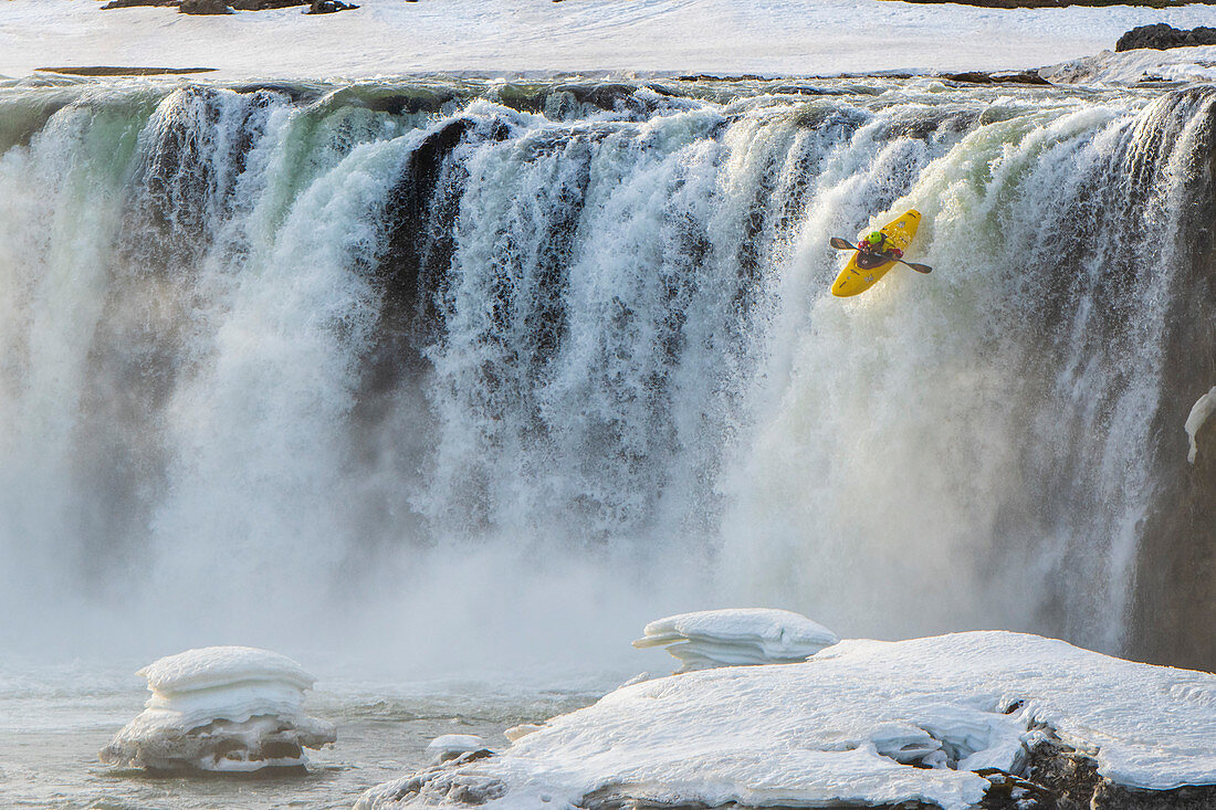 Kajakfahrer im eisigen Wasserfall Godafoss, Island im Winter