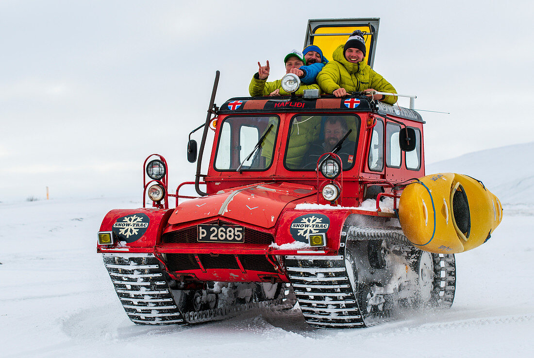 Abenteurer mit ihrem Kajak unterwegs in einem Schneemobil, Island