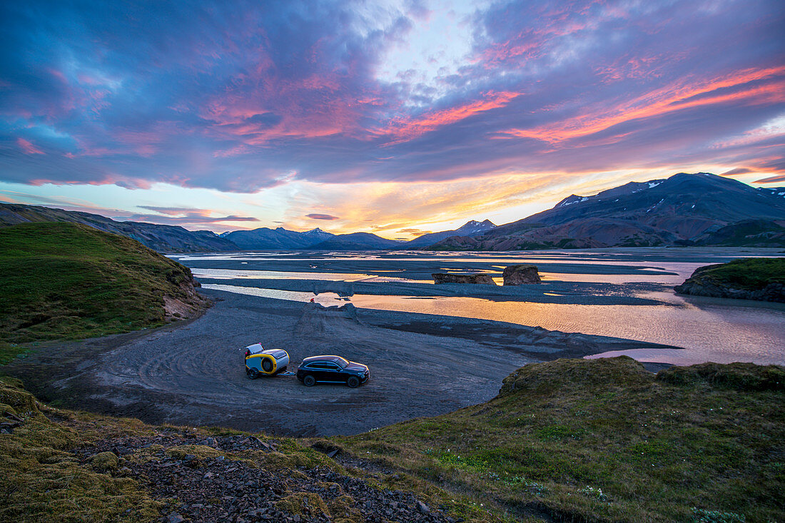 Mountainbiker genießen an ihrem kleinen Wohnwagen die herrliche Landschaft, Abendstimmung in Island