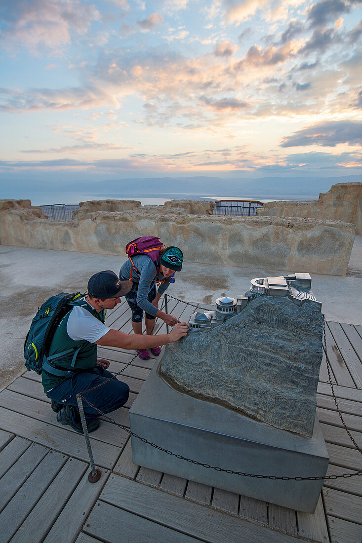 Zwei Wanderer unterwegs im Nationalpark Masada, betrachten ein Modell der Festung Masada, Israel