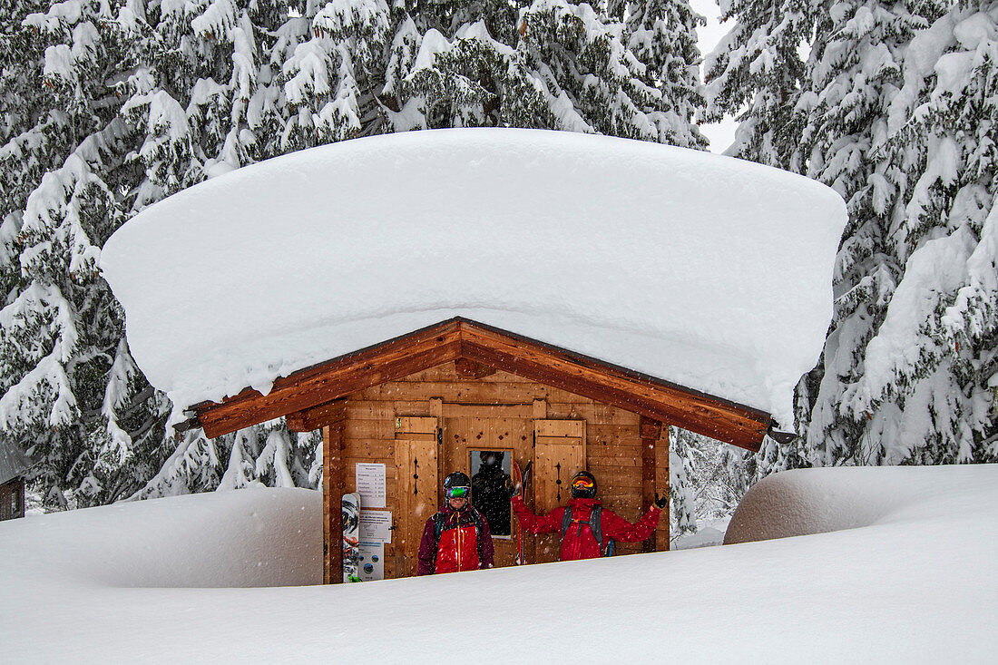 Skifahrer machen Pause unter eingeschneitem Mauthaus, Zillertaler Höhenstrasse, Hochzillertal, Tirol, Österreich