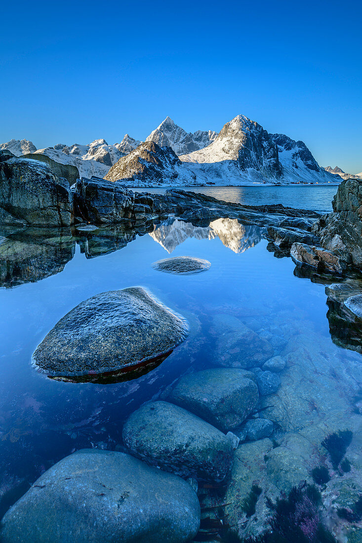 Snowy mountains are reflected in lake, Vareid, Lofoten, Nordland, Norway