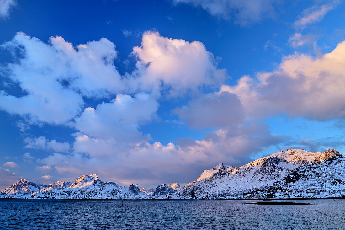 Wolkenstimmung über verschneiten Bergen und Fjord, Lofoten, Nordland, Norwegen