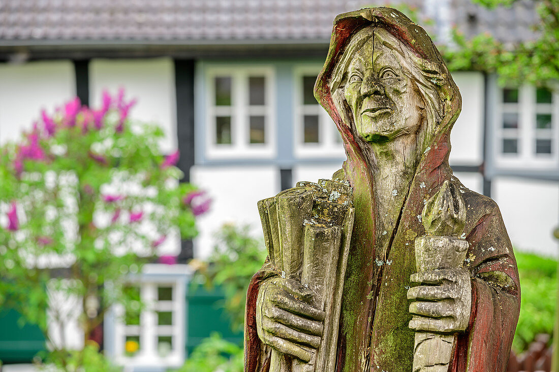 Wooden figure stands in front of half-timbered house, Blankenberg, natural area Sieg, Bergisches Hochland, North Rhine-Westphalia, Germany