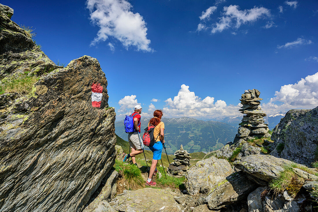Man and woman hiking look into the Zillertal, Stoamandlweg, Wimbachkopf, Zillertal, Tux Alps, Tyrol, Austria