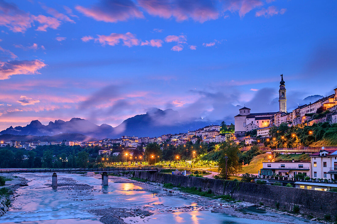 Beleuchtete Altstadt von Belluno über dem Fluss Piave mit Schiara-Gruppe im Hintergrund, Belluno, Dolomiten, UNESCO Welterbe Dolomiten, Venetien, Italien