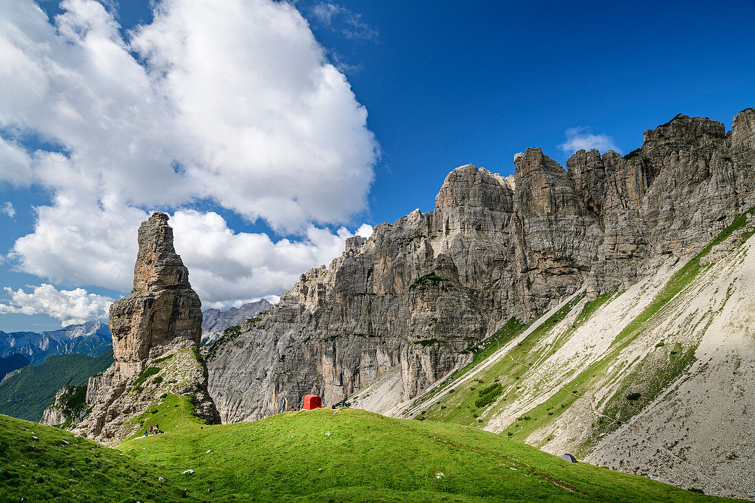 Felsturm mit kleiner roter Biwakschachtel steht vor Bergkulisse, Val Cimoliana, Dolomiten, UNESCO Welterbe Dolomiten, Venetien, Italien