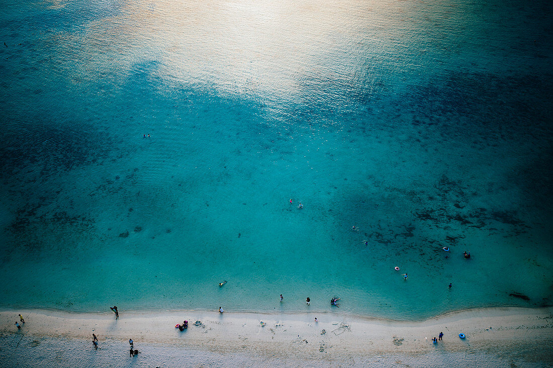 High angle view of crystal clear waters and white sandy beach.